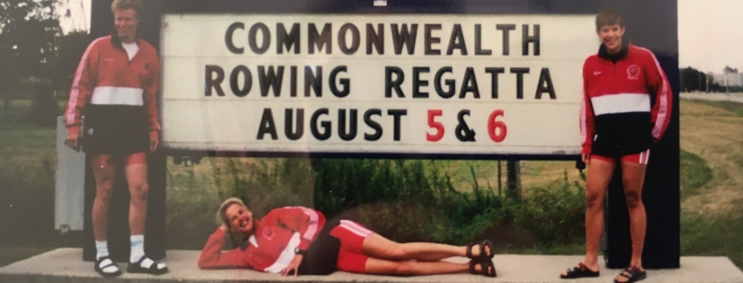 3 woen by sign saying Commonwealth Rowing Regatta, August 5 & 6
